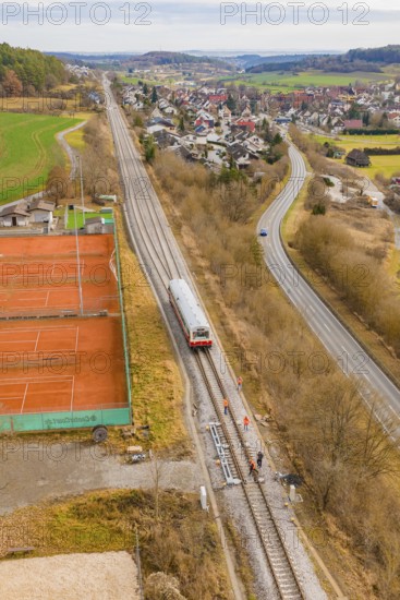 Overview of train travel along tennis courts on the outskirts of the city, historical event, first test run with a passenger train on the Hermann tracks, Hesse Railway since 1988, Ostelsheim, Calw district, Germany