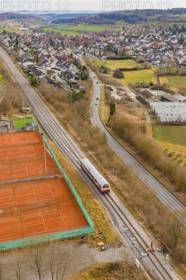 Train travels along tennis courts near a city, historic event, first test run with a passenger train on the Hermann tracks, Hesse railway since 1988, Ostelsheim, Calw district, Germany