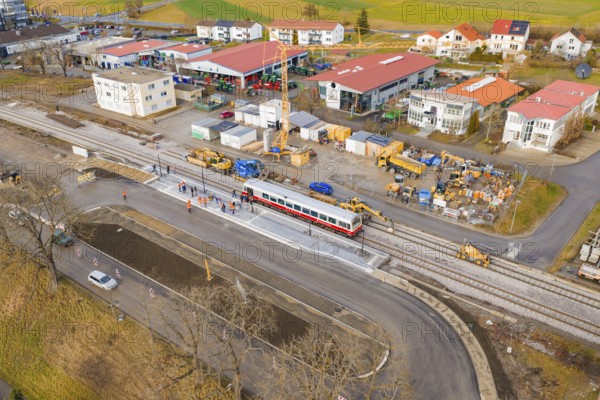 Workers and machines are working on an extensive construction site near tracks and a passing train, historic event, first test run with a passenger train on the Hermann tracks, Hesse Railway since 1988, Calw district, Germany