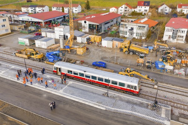 Workers work next to a train and tracks at a construction site with adjacent buildings, historic event, first test run with a passenger train on the Hermann tracks, Hesse Railway since 1988, Calw district, Germany
