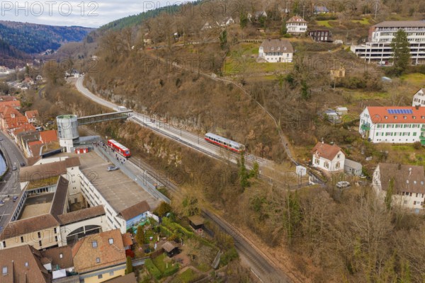 Zug crosses an urban landscape with hilly terrain and houses under a cloudy sky, historic event, first test run with a passenger train on the Hermann tracks, Hesse Railway since 1988, Calw. Calw District, Germany