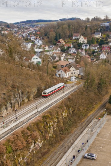 A train passes by a mountain range. In the background is a small town with many houses, historic event, first test run with a passenger train on the Hermann tracks, Hesse Railway since 1988, Calw, Calw district, Germany