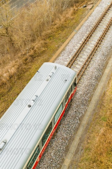 A train travels along the tracks through an autumn landscape. The sky is cloudy, historic event, first test run with a passenger train on the Hermann tracks, Hesse Railway since 1988, Calw district, Germany