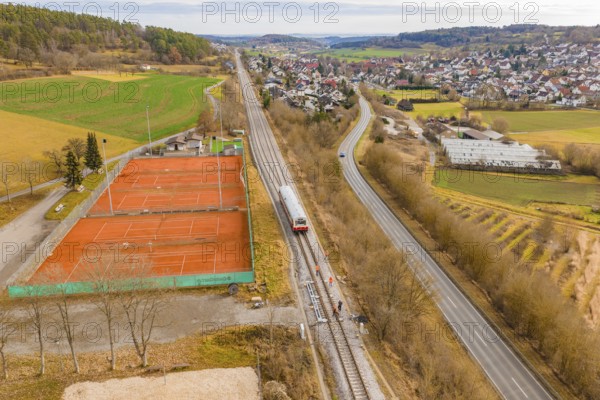 Panorama of a rural area with train next to tennis courts, historic event, first test drive with a passenger train on the Hermann tracks, Hesse Railway since 1988, Ostelsheim, Calw district, Germany