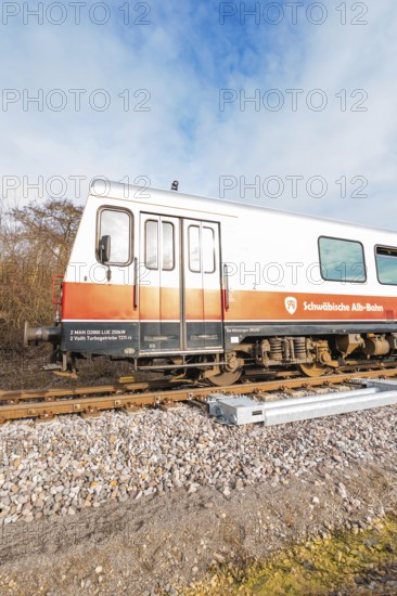 A train on rails under a blue sky with inscriptions visible on the wagons, historic event, first test run with a passenger train on the Hermann tracks, Hesse Railway since 1988, Calw district, Germany