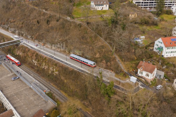 Zug moves through a varied landscape of hills and buildings in a wintry atmosphere, historic event, first test run with a passenger train on the Hermann tracks, Hesse Railway since 1988, Calw. Calw District, Germany