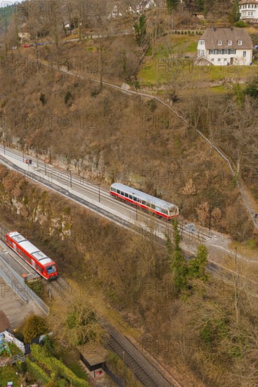 Train on tracks next to wooded hills with buildings in a wintry landscape, historic event, first test run with a passenger train on the Hermann tracks, Hesse Railway since 1988, Calw, Calw district, Germany