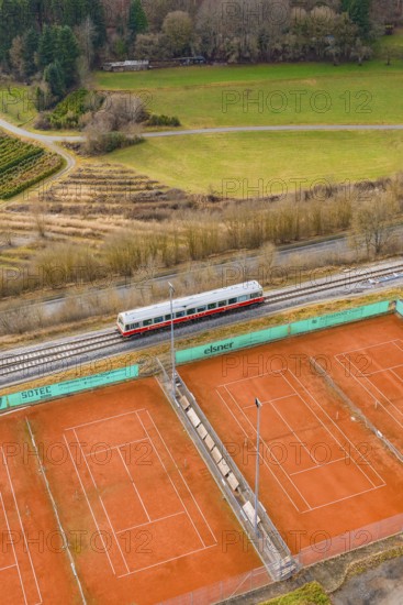 Landscape view with train next to tennis courts and meadows, historic event, first test run with passenger train on the Hermann tracks, Hesse Railway since 1988, Ostelsheim, Calw district, Germany