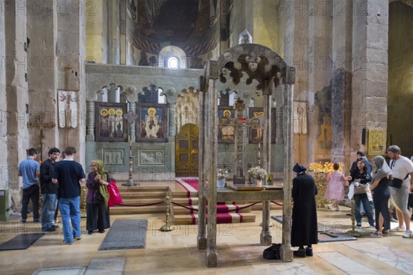 People in a traditional church interior near an altar with icon portraits, Svetitskhoveli Cathedral, Svetitskhoveli, UNESCO World Heritage Site, Mtskheta, Mtskheta, Mtskheta-Mtianeti region, Georgia
