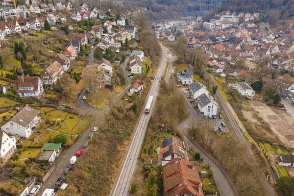 City with close-standing houses along a railway line through hilly, wooded landscape, historic event, first test run with a passenger train on the Hermann tracks, Hesse Railway since 1988, Calw, Calw district, Germany