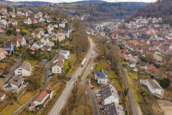 Urban landscape with railway line through hills with various houses and trees, historic event, first test run with a passenger train on the Hermann tracks, Hesse Railway since 1988, Calw, Calw district, Germany