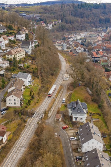Railway line through a rural town with residential buildings on hilly, wooded terrain, historic event, first test run with a passenger train on the Hermann tracks, Hesse Railway since 1988, Calw, Calw district, Germany