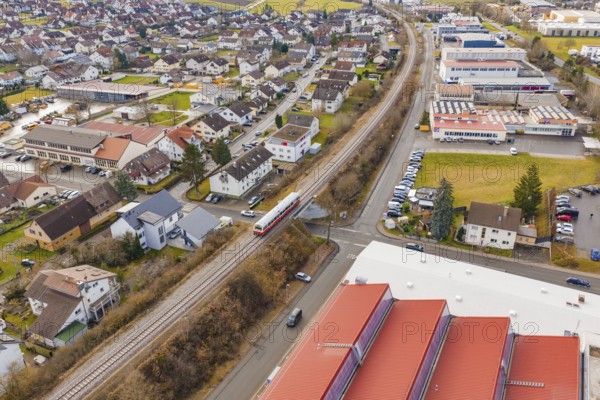 Train travels in a suburban landscape between residential buildings and industrial buildings, historic event, first test drive with a passenger train on the Hermann tracks, Hesse Railway since 1988, Althengstett, Calw district, Germany