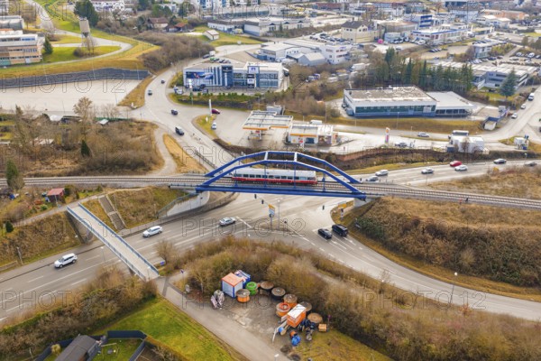 A train crosses a busy road junction in the city on a bridge, historical event, first test drive with a passenger train on the Hermann tracks, Hesse Railway since 1988, Calw, Heumaden, Calw district, Germany