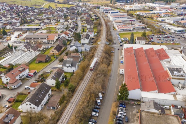 Train on rails in a suburb with residential buildings and industrial facilities, surrounded by roads, historic event, first test run with a passenger train on the Hermann tracks, Hesse Railway since 1988, Althengstett, Calw district, Germany