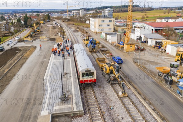 Train surrounded by workers and cranes at construction site, industrial buildings and vehicles in the background, historic event, first test drive with a passenger train on the Hermann tracks, Hesse Railway since 1988, Althengstett, Calw district, Germany