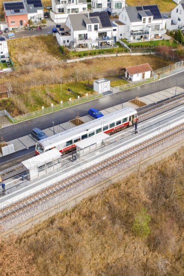 Train on the platform, surrounded by residential buildings and parked cars, historic event, first test run with a passenger train on the Hermann tracks, Hesse Railway since 1988, Ostelsheim, Calw district, Germany