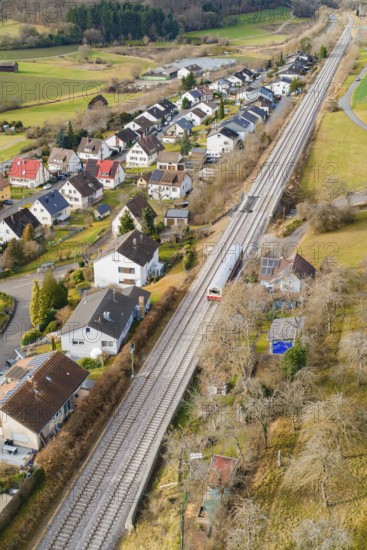 Rural area along railway tracks with houses and trees, historic event, first test run with a passenger train on the Hermann tracks, Hesse Railway since 1988, Ostelsheim, Calw district, Germany