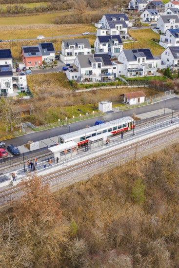 Train stops at a small train station next to modern houses surrounded by fields, historic event, first test run with a passenger train on the Hermann tracks, Hesse Railway since 1988, Ostelsheim, Calw district, Germany