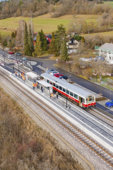 Train at the train station, surrounded by trees and small houses in a wintry landscape, historic event, first test run with a passenger train on the Hermann tracks, Hesse Railway since 1988, Ostelsheim, Calw district, Germany