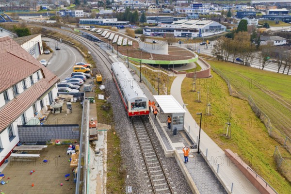 A train stops at a train station in an urban area, surrounded by buildings and parking lots, Historic Event, First test run with a passenger train on the Hermann tracks, Hesse Railway since 1988, Calw, Calw district, Germany