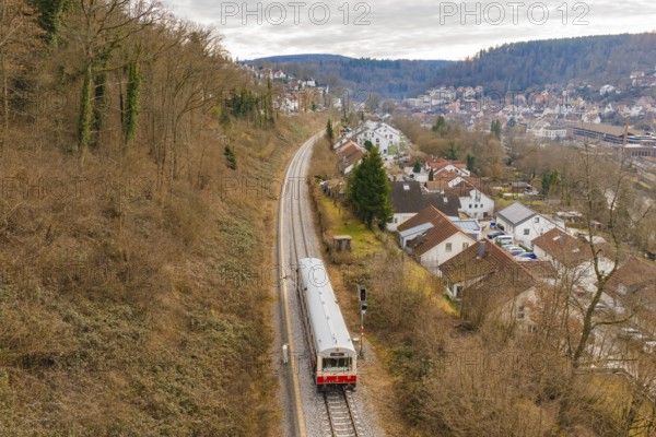 A train moves through a picturesque landscape with houses and hills in the background, historic event, first test run with a passenger train on the Hermann tracks, Hesse Railway since 1988, Calw, Calw district, Germany