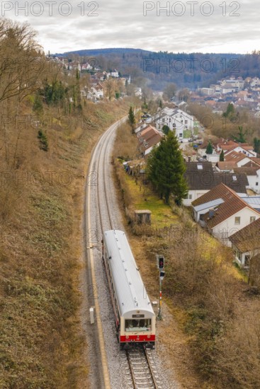A train travels through a hilly landscape with houses and autumn trees, historical event, first test run with a passenger train on the Hermann tracks, Hesse Railway since 1988, Calw, Calw district, Germany