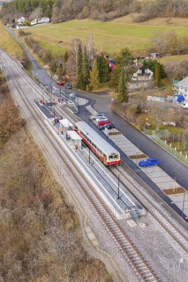 Small train station in a rural area with train, rails and surrounding countryside in autumn colors, historic event, first test run with a passenger train on the Hermann tracks, Hesse Railway since 1988, Ostelsheim, Calw district, Germany