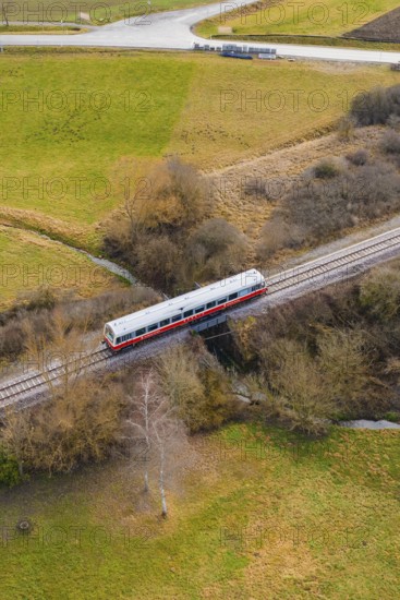 A train crosses a bridge over a river, surrounded by trees in a rural landscape, historic event, first test run with a passenger train on the Hermann tracks, Hesse Railway since 1988, Calw district, Germany