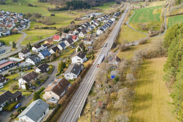 Railway tracks criss-cross a village backdrop with houses and green spaces, historic event, first test run with a passenger train on the Hermann tracks, Hesse railway since 1988, Ostelsheim, Calw district, Germany