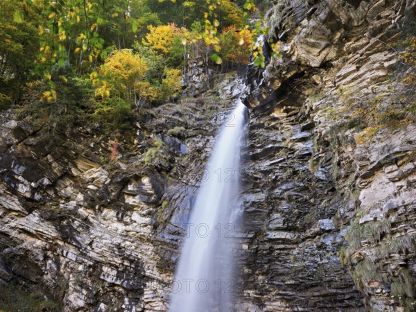 Diesbach waterfall in autumn-colored surroundings, Linthal, Klausenpass, Canton of Glarus, Switzerland