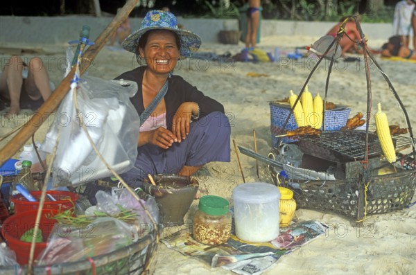 Woman with food stash on Pranang Cave beach laughing at the camera, two years in front of the tsunami, Krabi, Thailand, December 2002, vintage, retro, old, historic