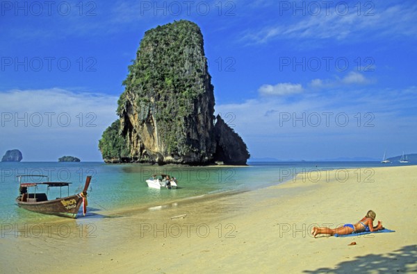 Rocks in the sea, people and longtail boat on Pranang Cave beach, two years in front of the tsunami, Krabi, Thailand, December 2002, vintage, retro, old, historic