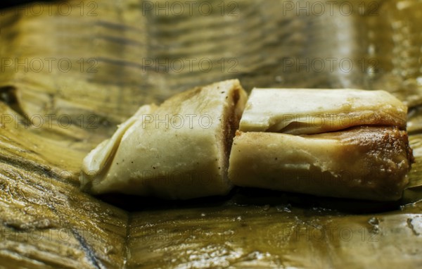 Close up of a traditional tamale on a banana leaf. Nicaraguan pisque tamale on banana leaf. Tamalpisque traditional Central American food, Stuffed tamale served in banana leaves