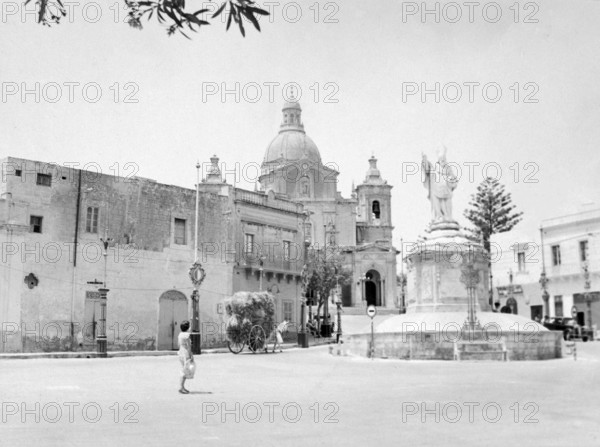 Statue of Saint Nicholas, Pjazza San Nikola, St Nicholas Square, village of Siggiewi, Malta, Europe, church in the background is the Parish Church of St. Nicholas, 1956