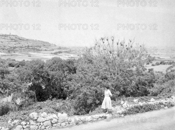 Young woman wearing summer dress standing in rural countryside area, Island of Gozo, Malta, Europe, 1956