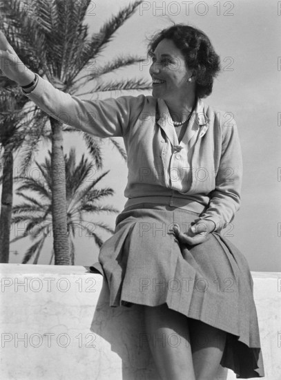 Portrait of middle aged woman sitting on wall, wearing smart casual clothing, Malta, Europe, 1956