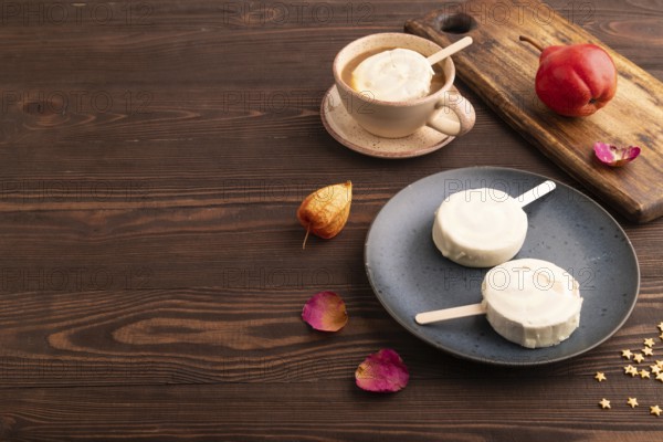 ?hocolate Ice cream in white glaze, cup of coffee, on brown wooden background, side view, copy space