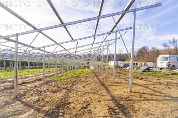 Unfinished solar system in open area with vehicles and building materials, energy transition, construction of PV open space, Baden-Württemberg, Germany