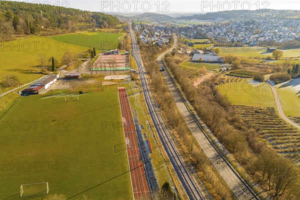 Aerial view of a railway bordering fields and a sports field in a rural area, construction of the Hermann Hesse Railway, Calw, Germany