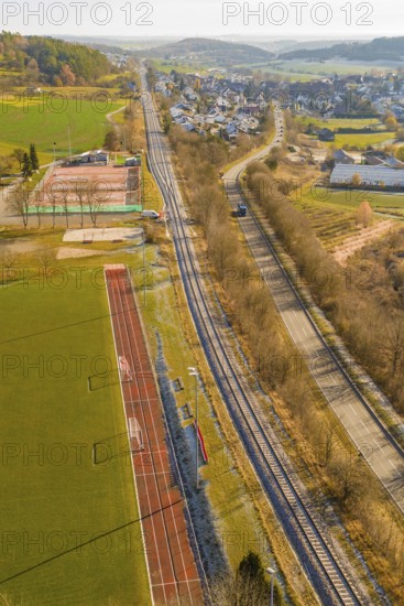 Railway line and road next to a sports field in a rural area, construction of the Hermann Hesse Railway, Calw, Germany