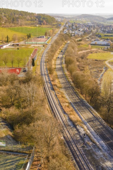 Rails and roads in a rural area with an adjacent village, construction of the Hermann Hesse Railway, Calw, Germany