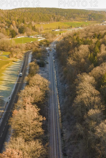 Railway line between trees and a country road in an autumn landscape, construction of the Hermann Hesse Railway, Calw, Germany