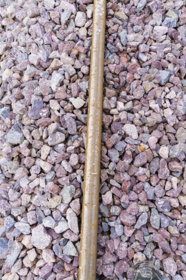 Close-up of gravel and a metal bar in a detailed view of the tracks, construction of the Hermann Hesse Railway, Calw, Germany