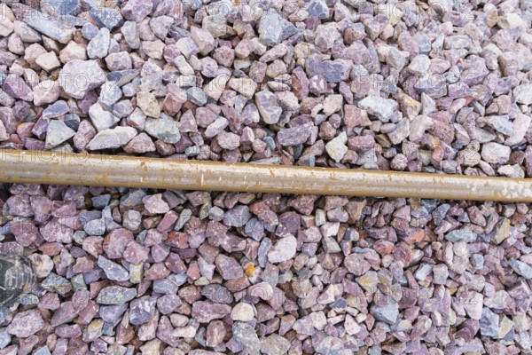 Close-up of gravel on railroad tracks with a metal rod as a contrast, construction of the Hermann Hesse Railway, Calw, Germany