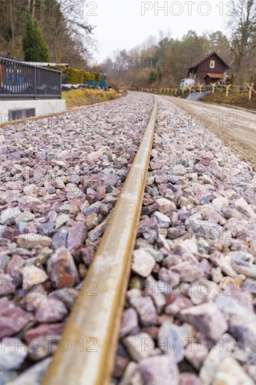 Railway tracks lead past a house through a rural, cloudy landscape, built by the Hermann Hesse Railway, Calw, Germany