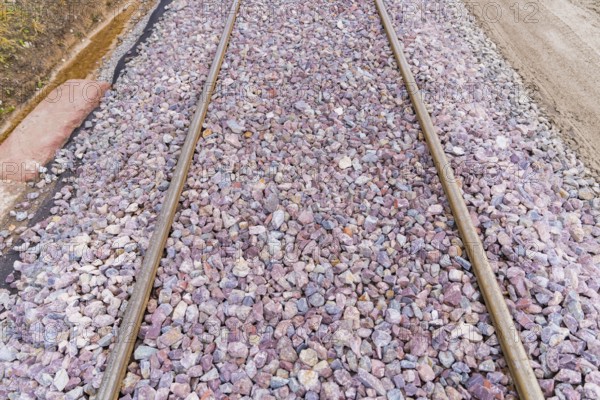Close-up of railroad tracks covered with grey and purple gravel, construction of the Hermann Hesse Railway, Calw, Germany