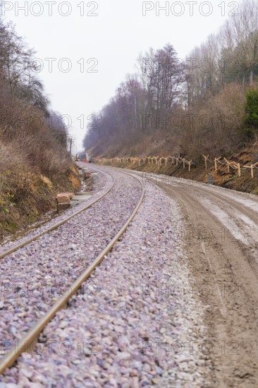 Railway tracks wind their way through a wooded, quiet landscape under cloudy skies, built by the Hermann Hesse Railway, Calw, Germany