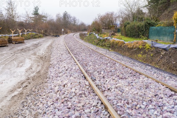 Railway tracks run curvy through a wooded landscape covered with gravel, construction of the Hermann Hesse Railway, Calw, Germany