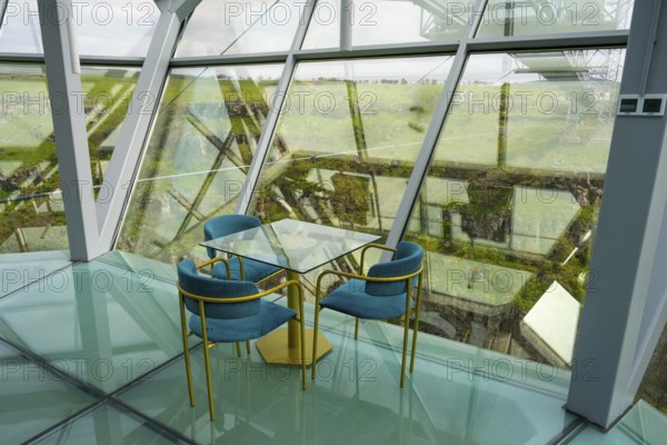 A stylish interior with glass floor and modern blue chairs offers an open view, Diamond Bridge, Diamond Glass Bridge, world's longest free-hanging structure, Dashbashi Gorge, Khrami River, Chrami, Tsalka Nature Reserve, Kartli, Georgia